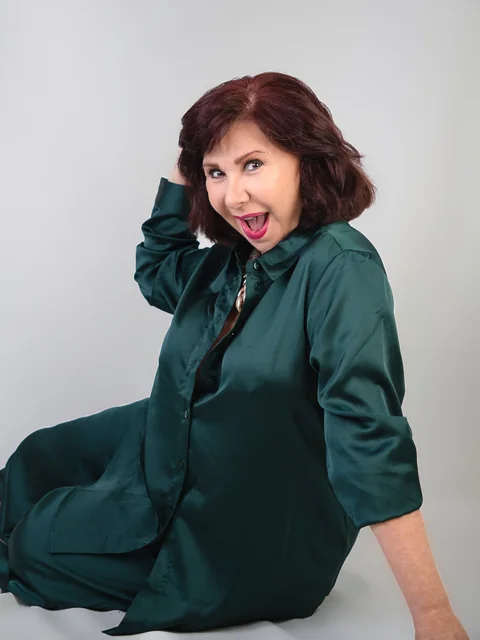 Marycarmen Sobrino, sonriente con un conjunto verde, en un retrato de Liliany